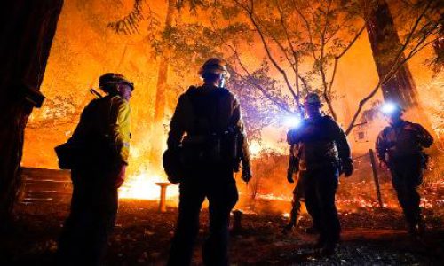 Firefighters make a stand in the backyard of a home in front of the advancing CZU August Lightning Complex Fire Friday, Aug. 21, 2020, in Boulder Creek, Calif. (AP Photo/Marcio Jose Sanchez)